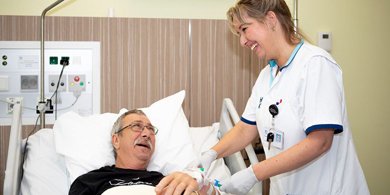 Patiënt wordt aan bed verzorgd door een verpleegkundige