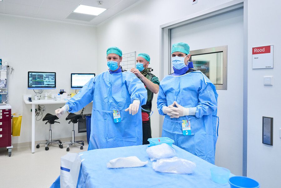 Laboranten trekken beschermende kleding aan voor het maken van de CT scan